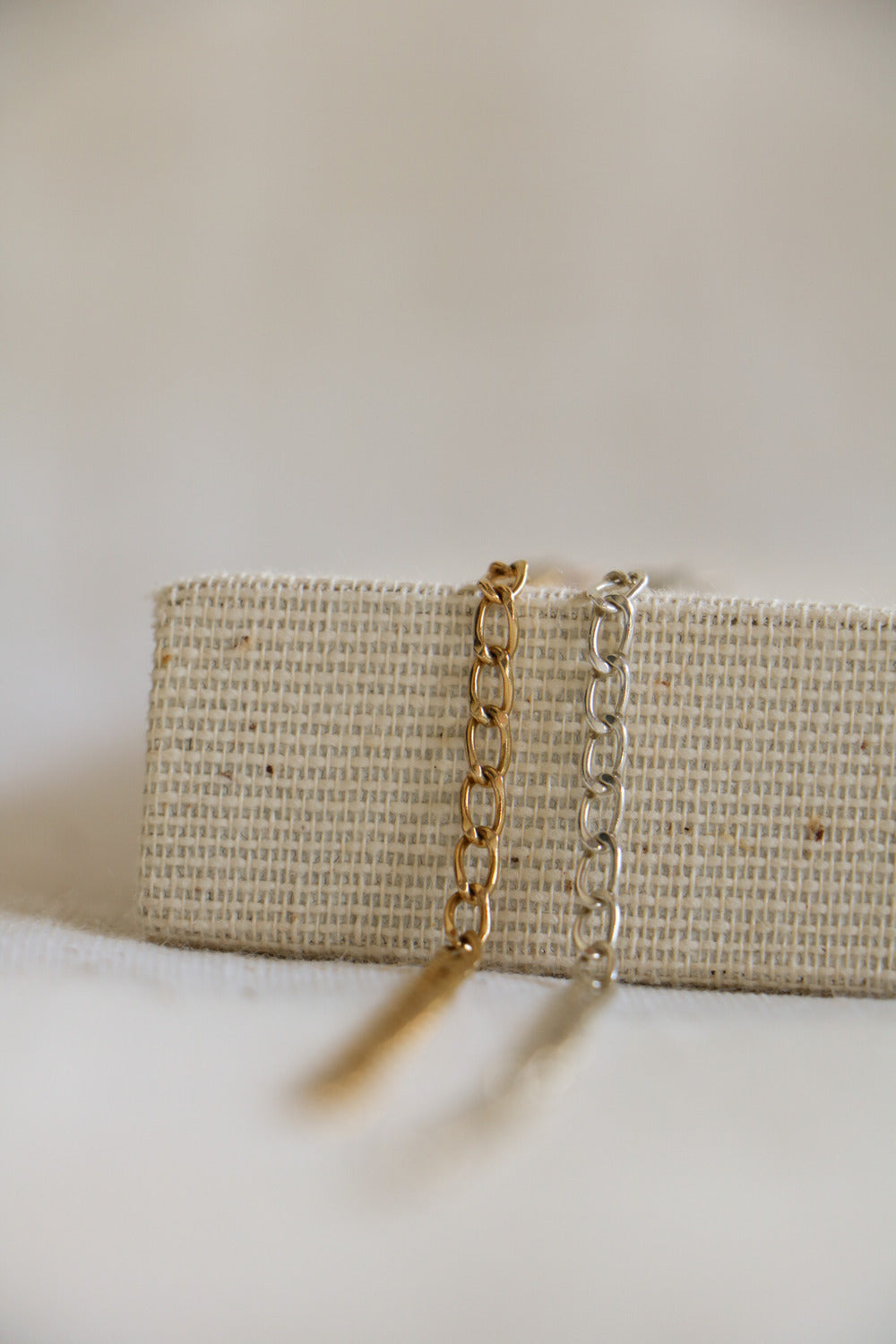 Gold-filled and sterling silver 3mm chains on a woven background, used for permanent jewelry at Charm City Links in Baltimore, Maryland.