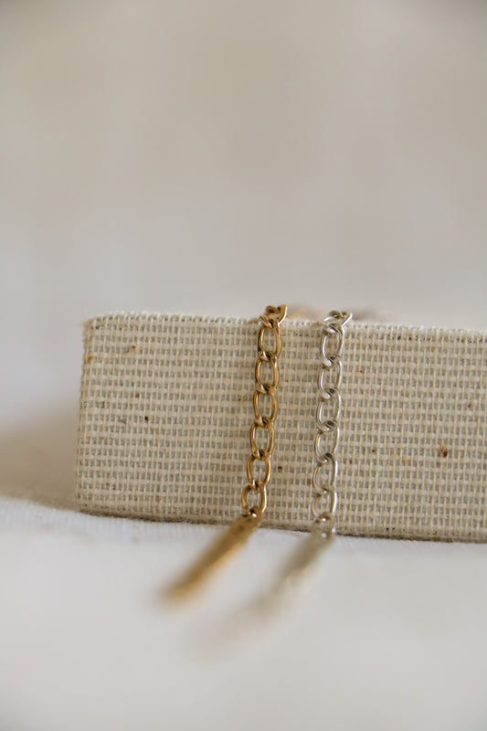 Gold-filled and sterling silver 3mm chains on a woven background, used for permanent jewelry at Charm City Links in Baltimore, Maryland.