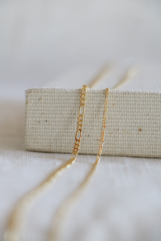 Yellow gold permanent jewelry links, including three small ovals followed by one large one in a pattern. Used in permanent bracelets, anklets, and necklaces.