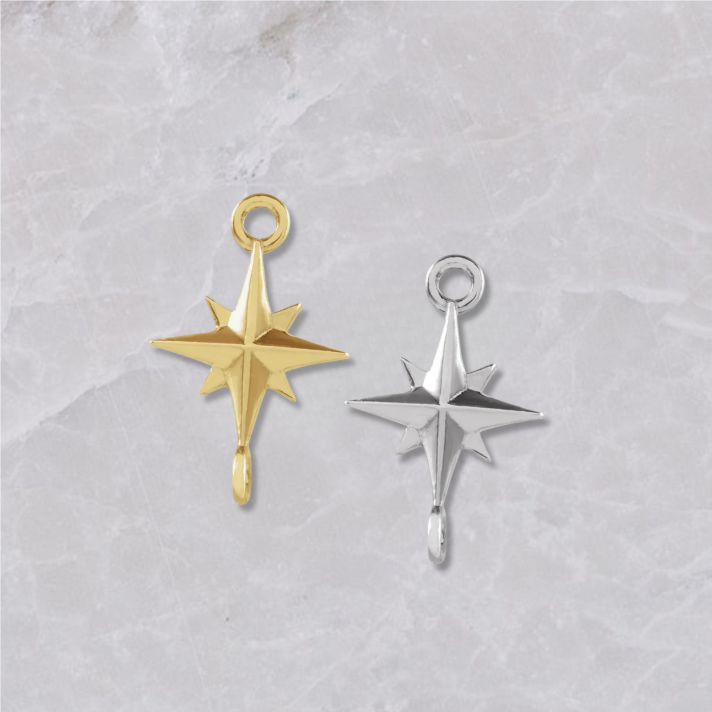 Two permanent jewelry connectors on a marble background. Shaped like starbursts with 4 points and connectors on top and bottom. Left is shown in 14k yellow gold, right is sterling silver.