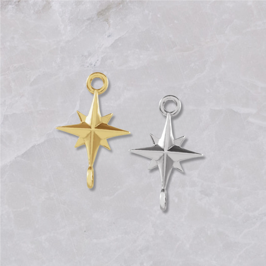 Two permanent jewelry connectors on a marble background. Shaped like starbursts with 4 points and connectors on top and bottom. Left is shown in 14k yellow gold, right is sterling silver.