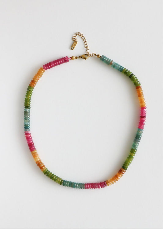 Rainbow necklace inspired by vintage candy, including pink, orange, green, and blue beads of different shades, attached by a gold clasp.